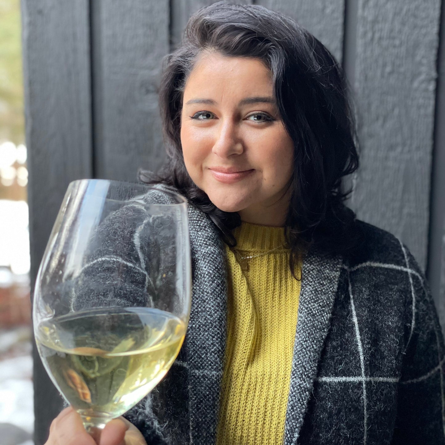 Woman holding a glass of white wine outdoors